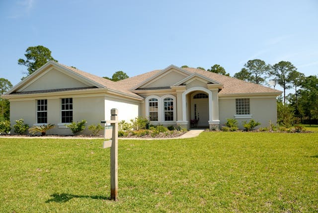 A large home with a sign in the yard.