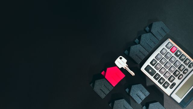 a calculator with houses and a key on a black background