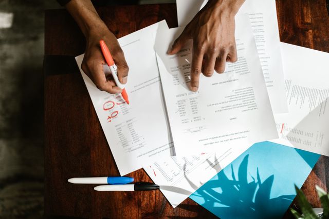 an overhead view of hands highlighting financial documents