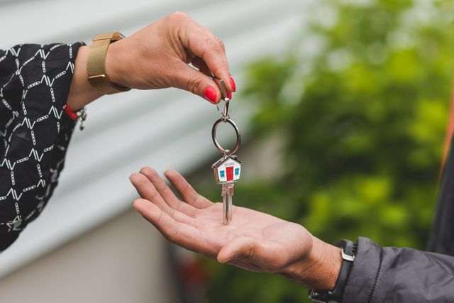 close up of someone passing a house key to someone else