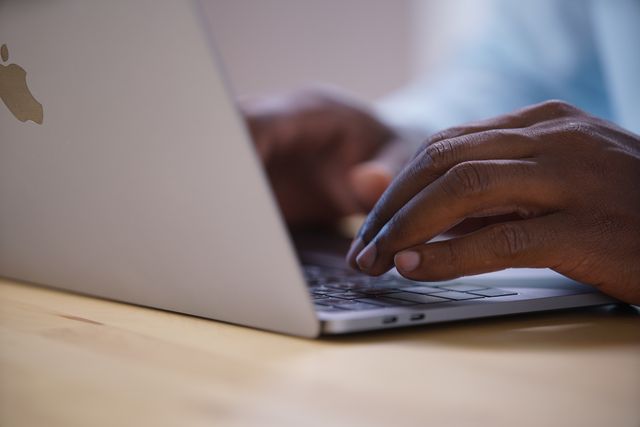 hands typing on a laptop keyboard
