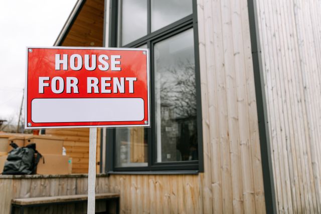 house with a for rent sign in front of it