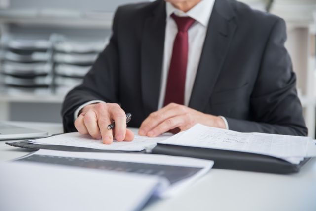person reviewing documents at an office desk