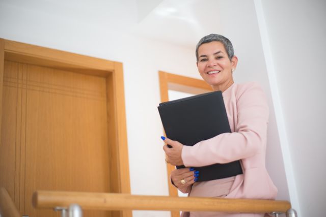 person smiling while holding documents