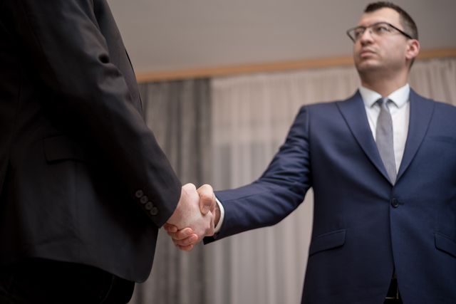 two people in formal attire shaking hands