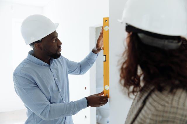 person measuring length of a wall